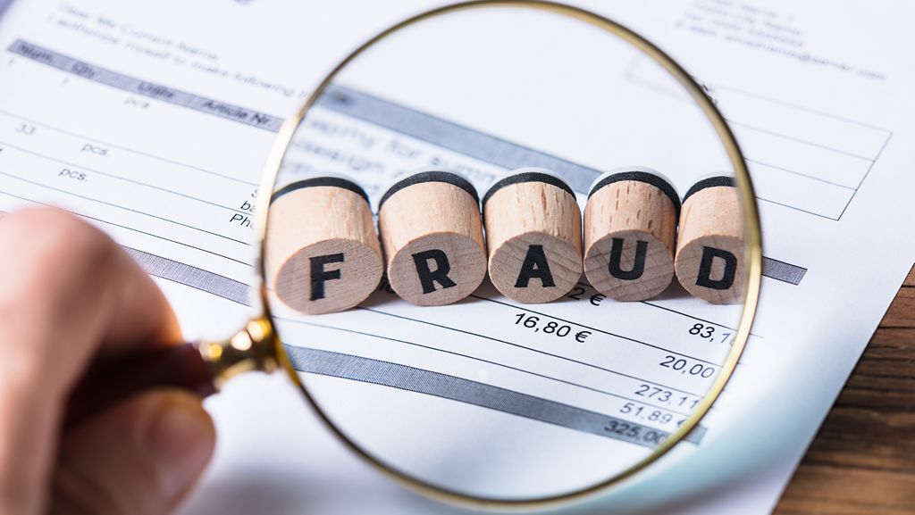 Magnifier pointing at fraud blocks concept